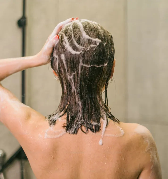 A person using a hair treatment to remove buildup