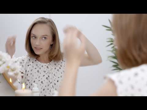 Video on how to use organic dry shampoo for natural haircare - cover photo is a women looking in the mirror as she applies natural dry shampoo