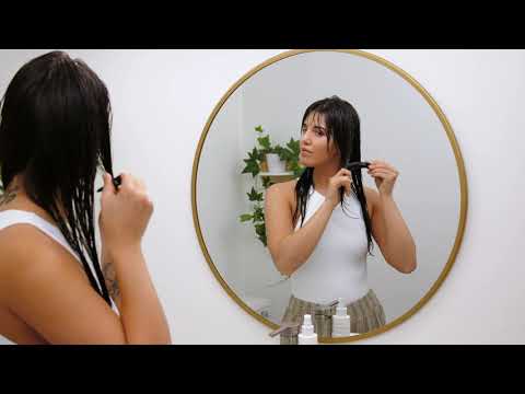 Video on how to increase your hair's natural hydration - clean beauty hair tips - cover photo is of a woman detangling her long hair in the mirror