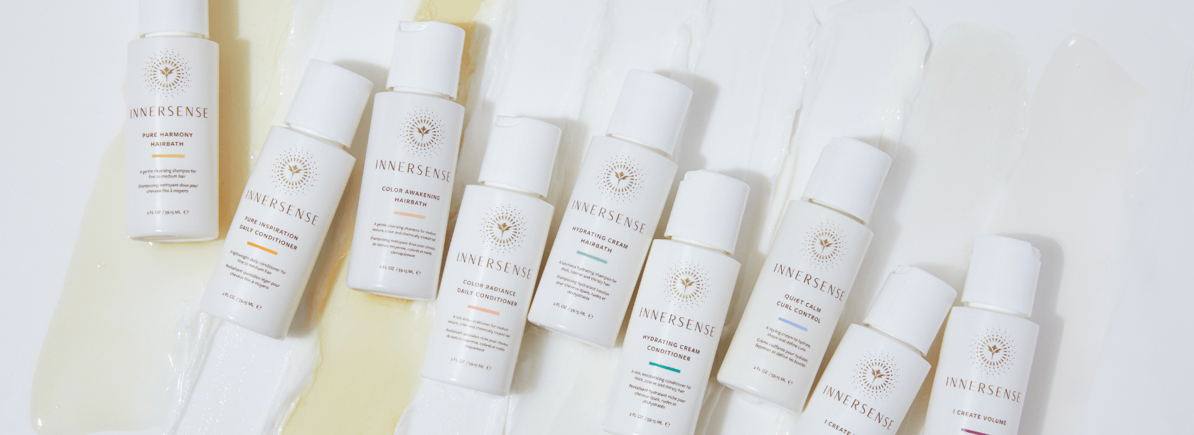 Row of white skincare bottles with visible branding on a light background